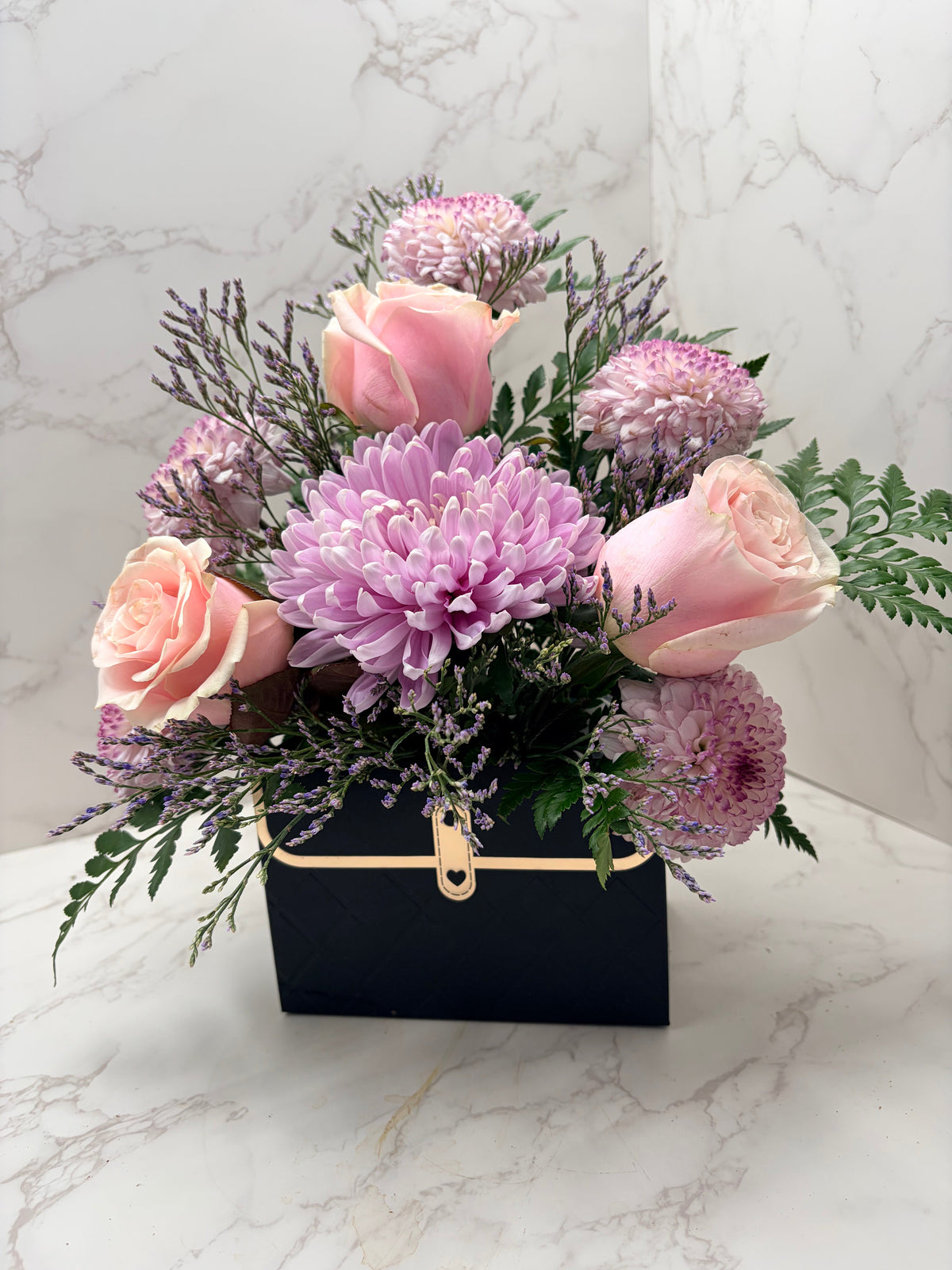 Rose Runners soft blush pink roses and lavender chrysanthemums in a black decorative container